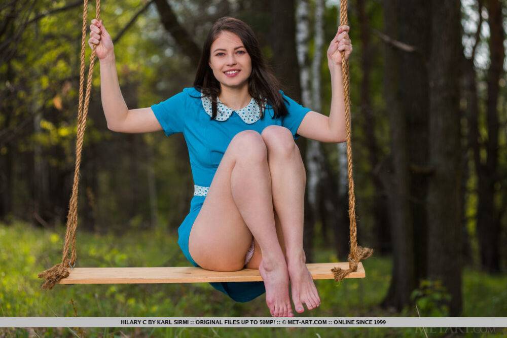 Young brunette Hilary C is encouraged to get naked on swing set in forest - #9