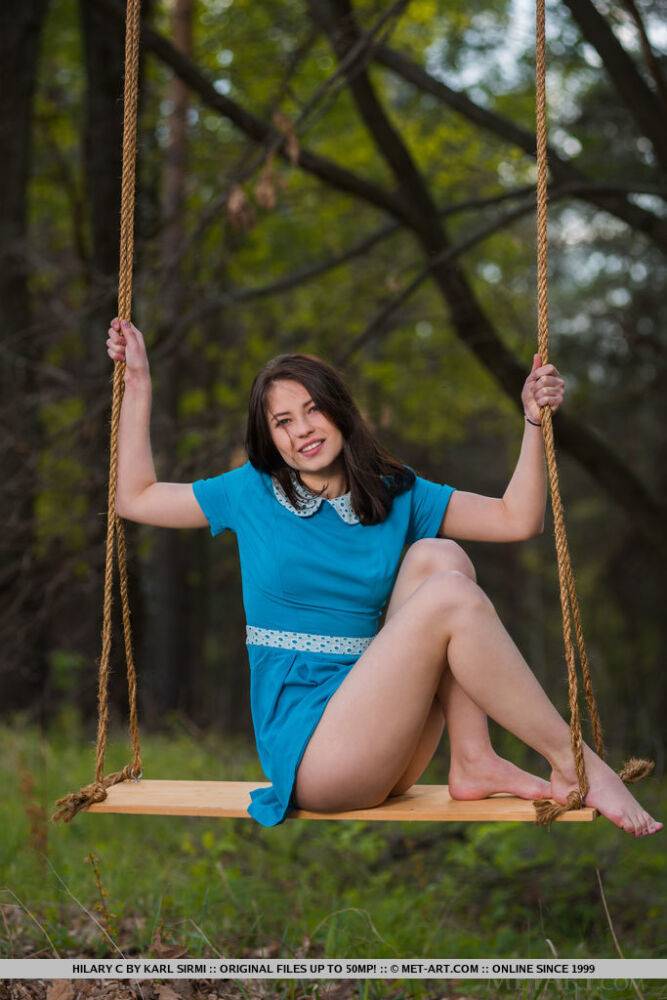 Young brunette Hilary C is encouraged to get naked on swing set in forest - #5