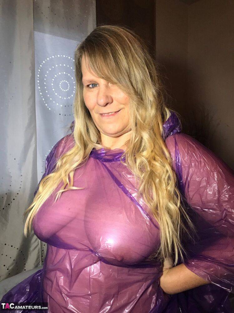 Mature amateur Sweet Susi lifts up a see-through raincoat to show her snatch | Photo: 1325673