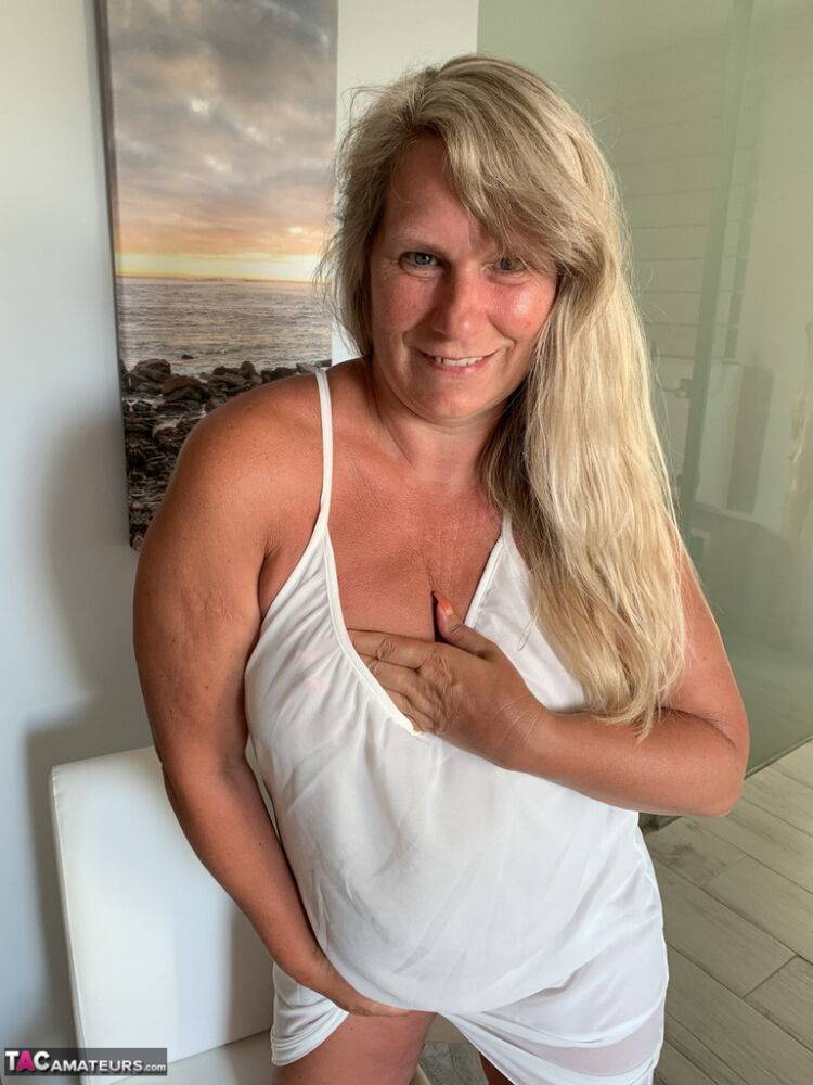 Thick older woman Sweet Susi exposes tan lined tits after hiking up her dress - #1