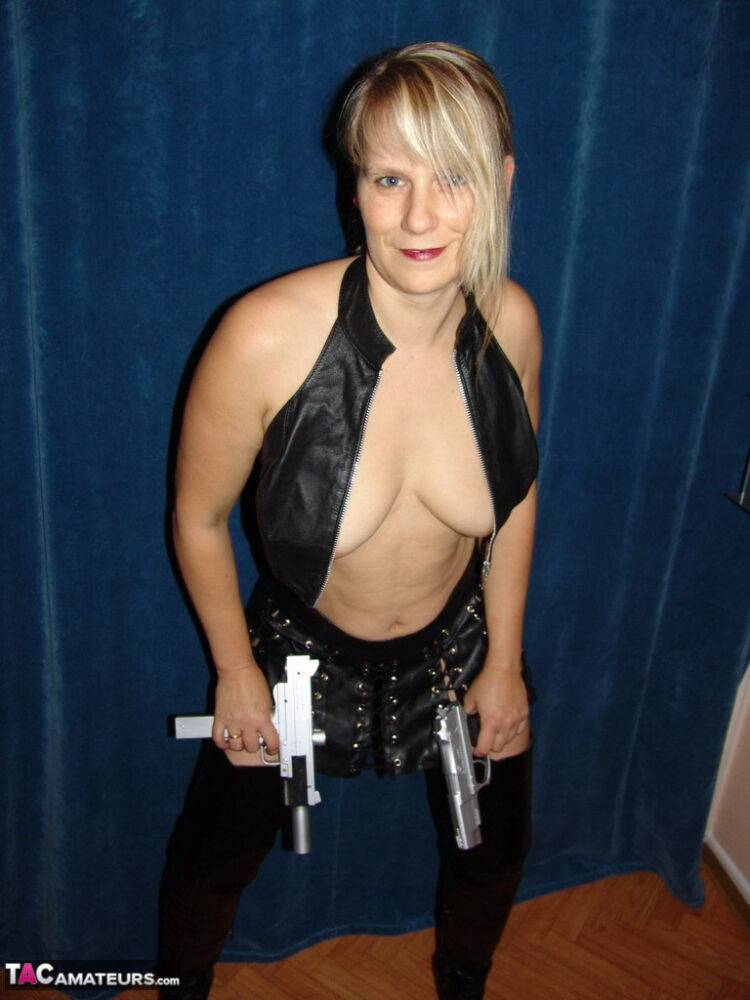 Blonde amateur Sweet Susi holds handguns while getting naked in long boots | Photo: 1327702