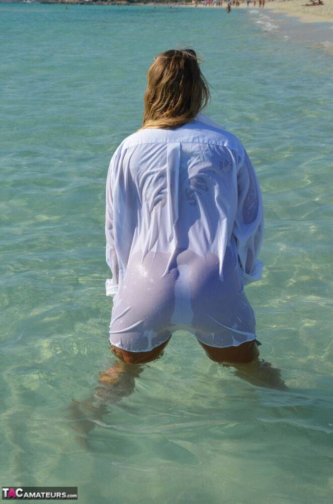 Blonde amateur Sweet Susi steps into the ocean while naked in a white shirt - #10