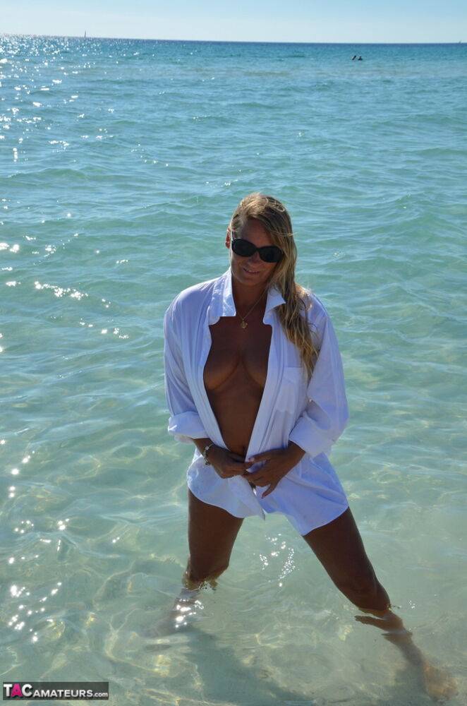 Blonde amateur Sweet Susi steps into the ocean while naked in a white shirt - #11