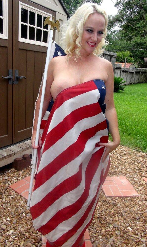 Blond amateur Dee Siren holds a USA flag while showing her big tits in a thong - #11