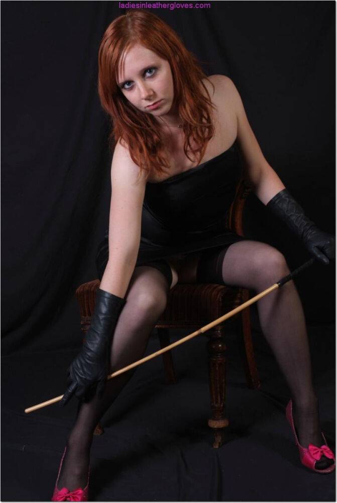 Natural redhead holds a cane with leather gloves while exposing her pink slit - #12