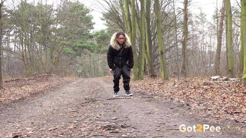 Solo girl Natasha Ink squats for a pee on a dirt road in glasses and a coat - #6