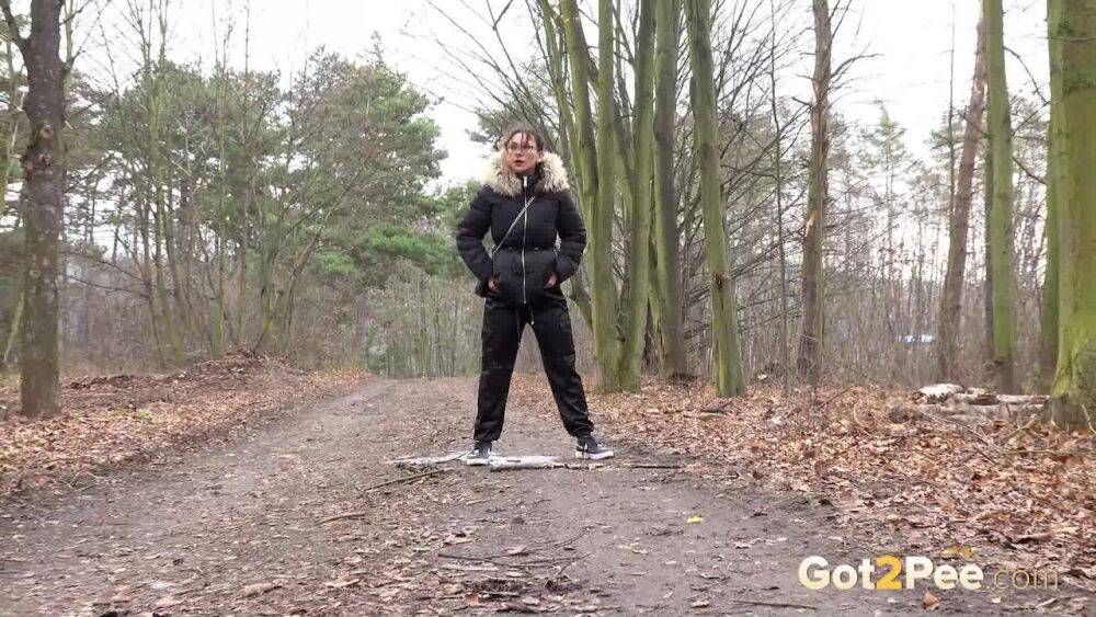 Solo girl Natasha Ink squats for a pee on a dirt road in glasses and a coat - #14