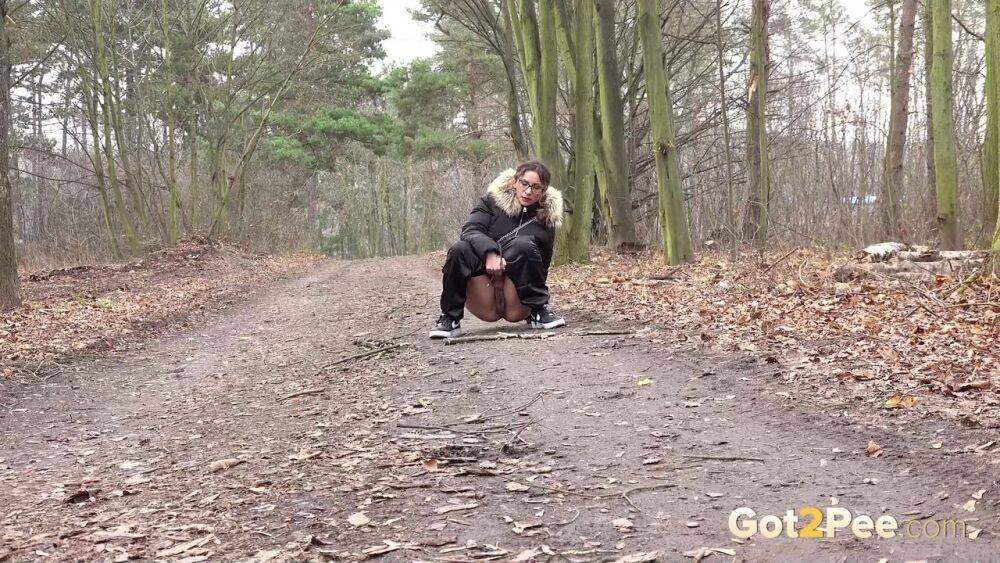 Solo girl Natasha Ink squats for a pee on a dirt road in glasses and a coat - #8