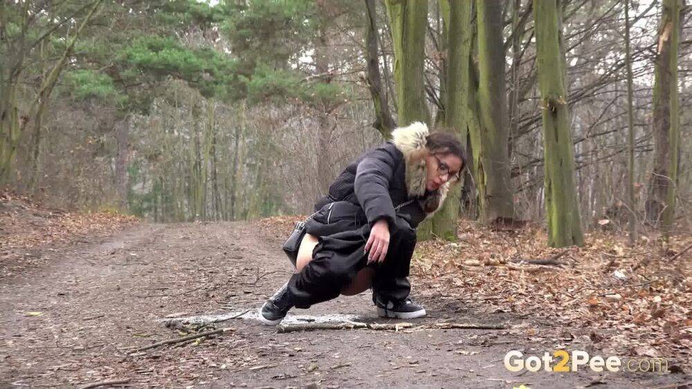 Solo girl Natasha Ink squats for a pee on a dirt road in glasses and a coat - #10