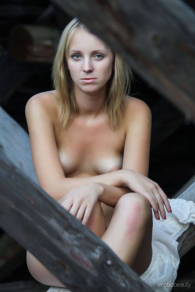 Young blonde Ilona D gets naked in a rustic setting with her boots on - #1