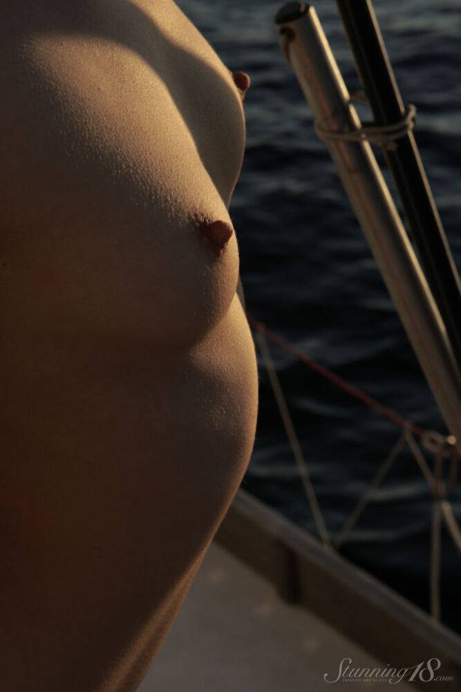 Barely legal brunette Roza A poses totally naked against a sail on a sailboat - #1