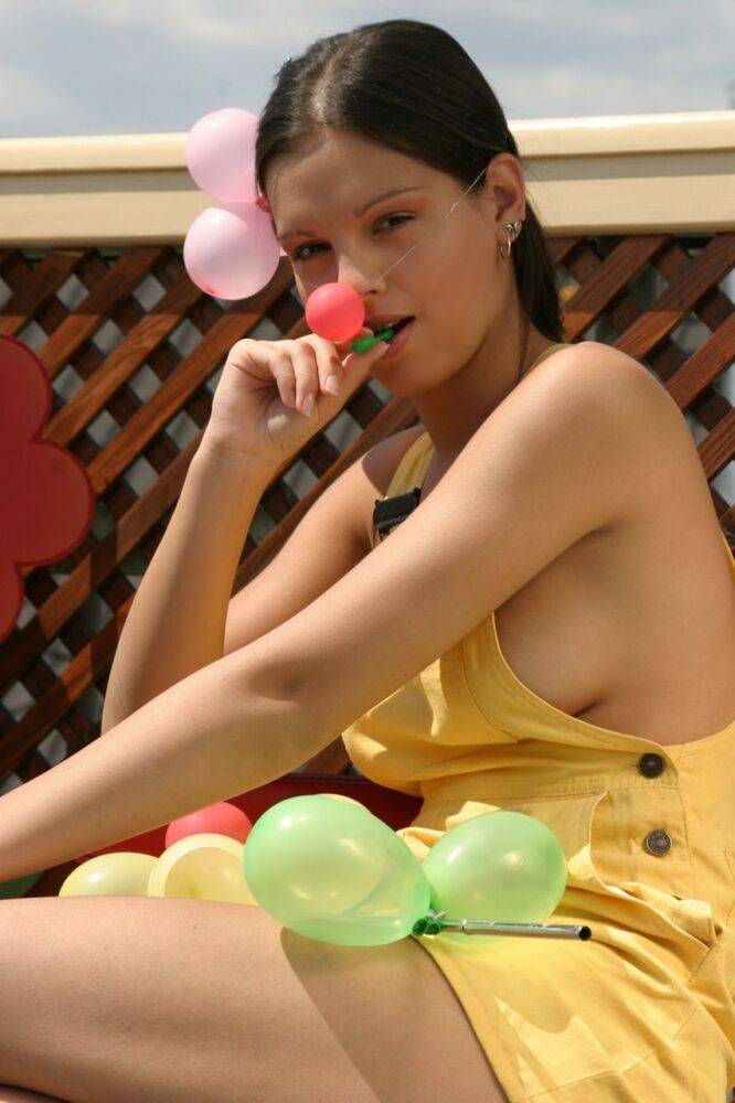 Beautiful girl Sweet Eva gets naked while blowing up balloons on a patio - #14