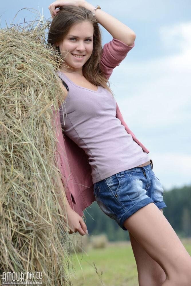 Pretty brunette Rumba squats naked in a hay field to reveal her shaved pussy - #8