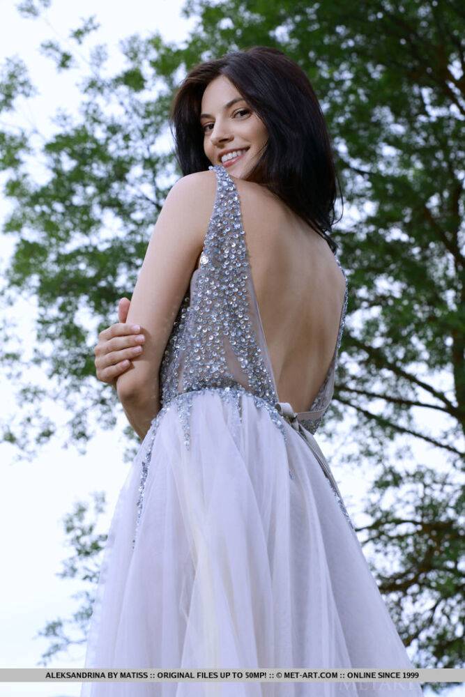 Dark haired teen Aleksandrina slips off a prom dress to pose naked in a field - #12