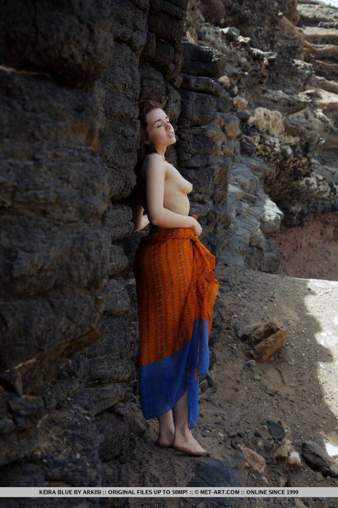 Young brunette Keira Blue models completely naked against a rock face - #1