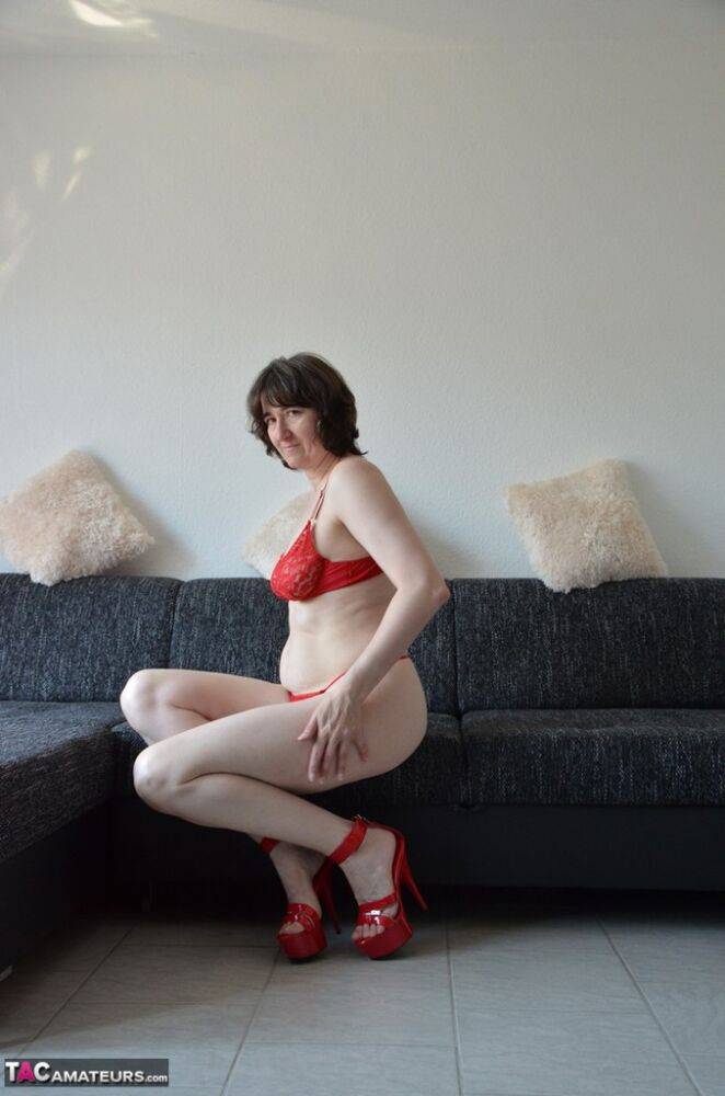 Solo model Hot MILF kicks off red panties with matching heels on a sofa - #16