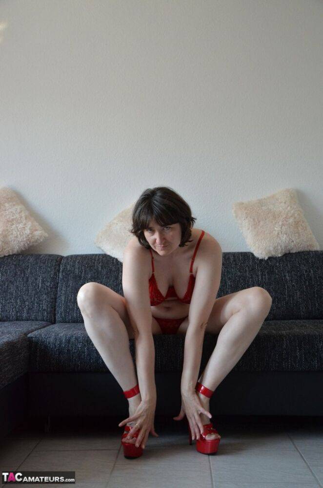 Solo model Hot MILF kicks off red panties with matching heels on a sofa - #1