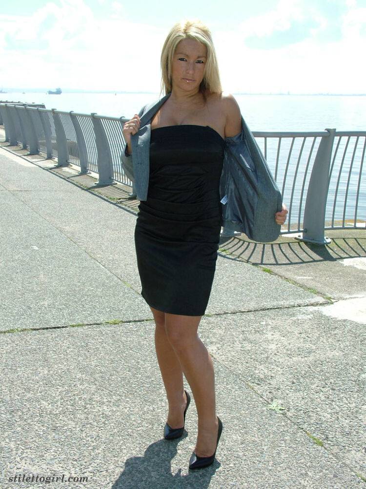 Blonde woman in black dress and pumps goes for a walk near the ocean - #2