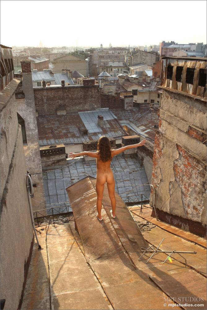 Solo girl with perky tits and a bald pussy models in the nude on rooftops - #5