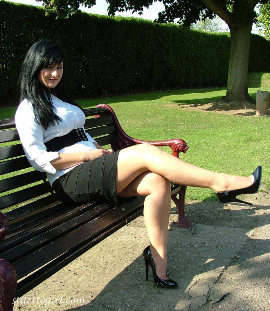 Dark haired female displays some leg and her stiletto heels on a park bench - #3