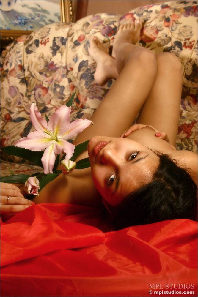 Pretty girl holds a long-stemmed flower while modelling in the nude - #2