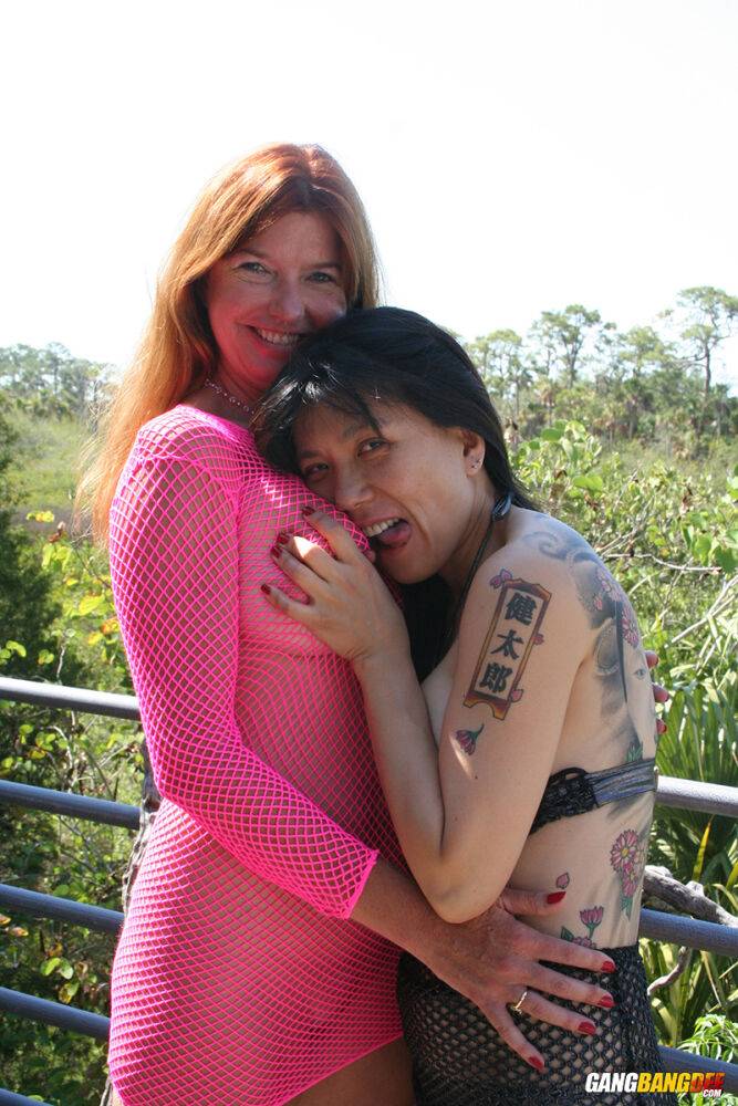 Mature redhead Dee Delmar and a tattooed girl blow a black dick together - #13