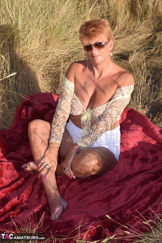 Fit older lady Dimonty exposes big naturals on a blanket overlooking the ocean - #8