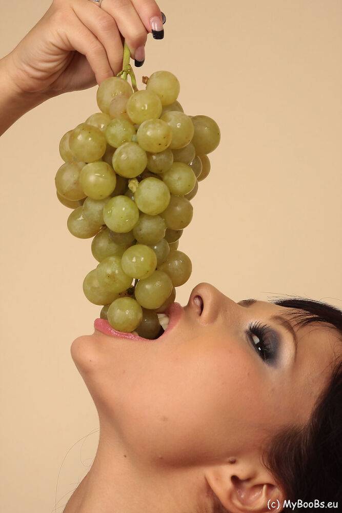 Hot brunette Domino munches on a grape bunch while removing her clothes - #13