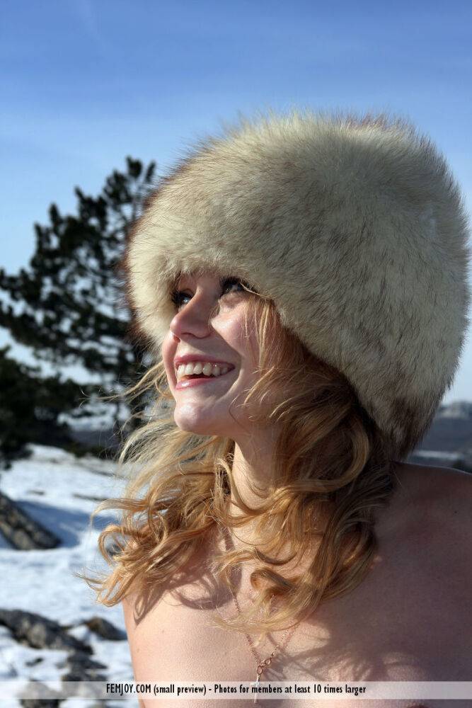 Tiny girl shows off her tan lined figure in a big fur hat out on snowy barrens - #16