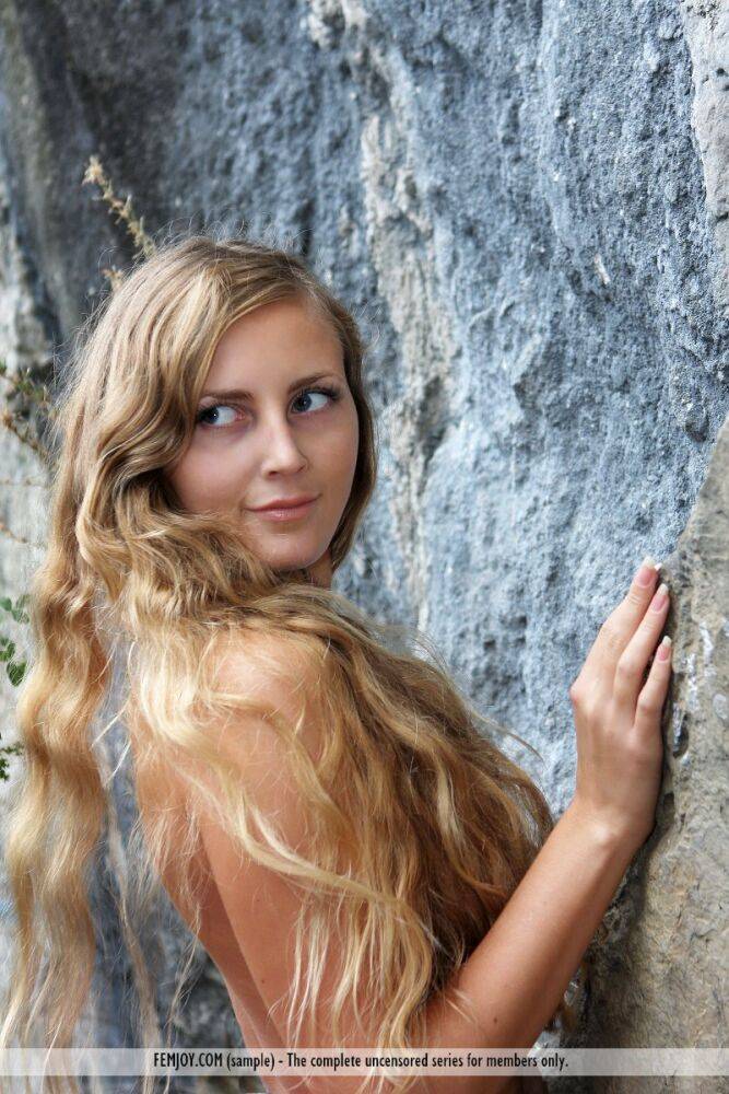 Totally naked girl Merit hits upon great poses in front of a sheer rock face - #13