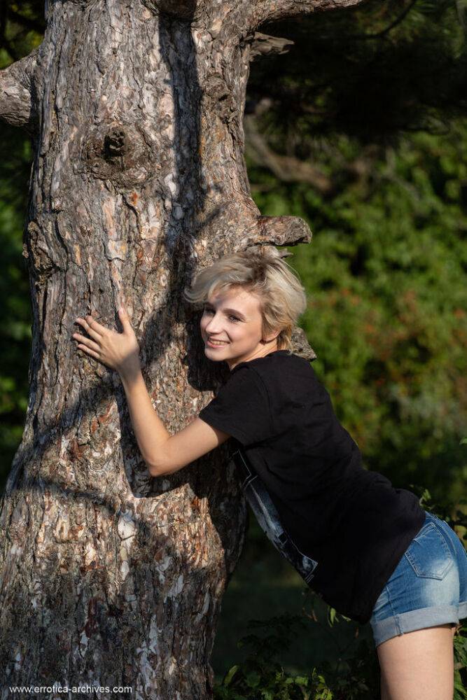 Skinny blonde Azshara strips bare naked in front of a mature tree - #14