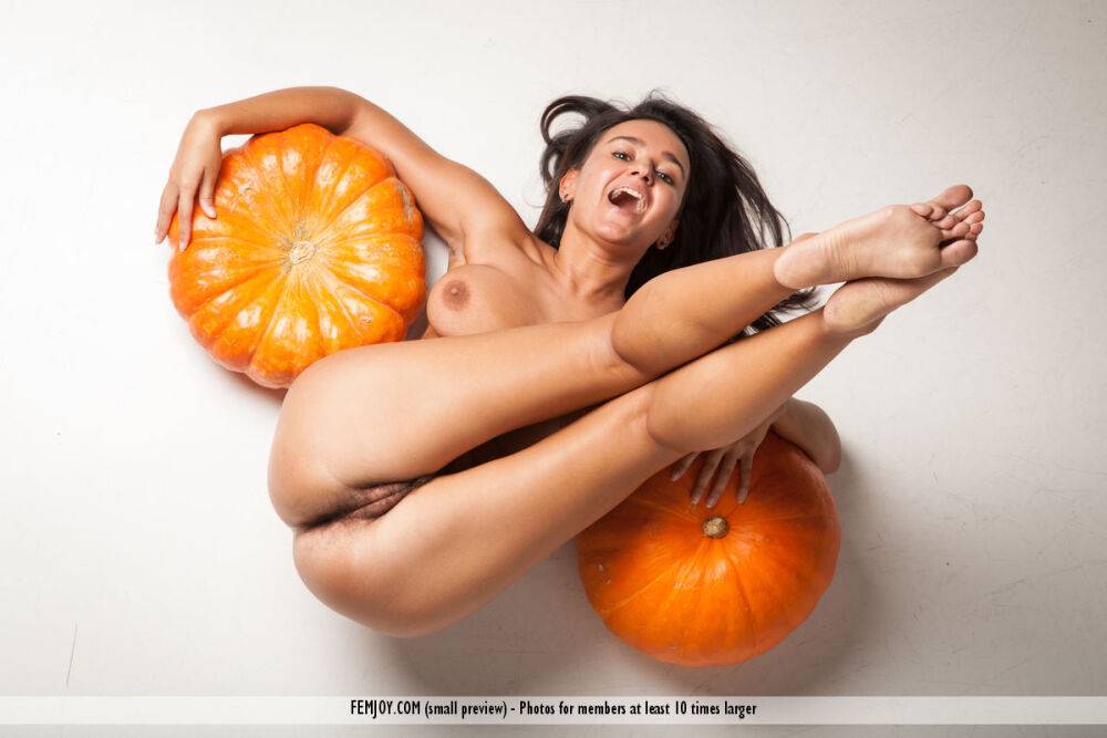 Naked brunette teen with big naturals and a trimmed bush models among pumpkins - #14