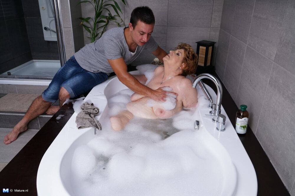 Obese older woman sinks into a bubble bath before unzipping her toy boy - #13