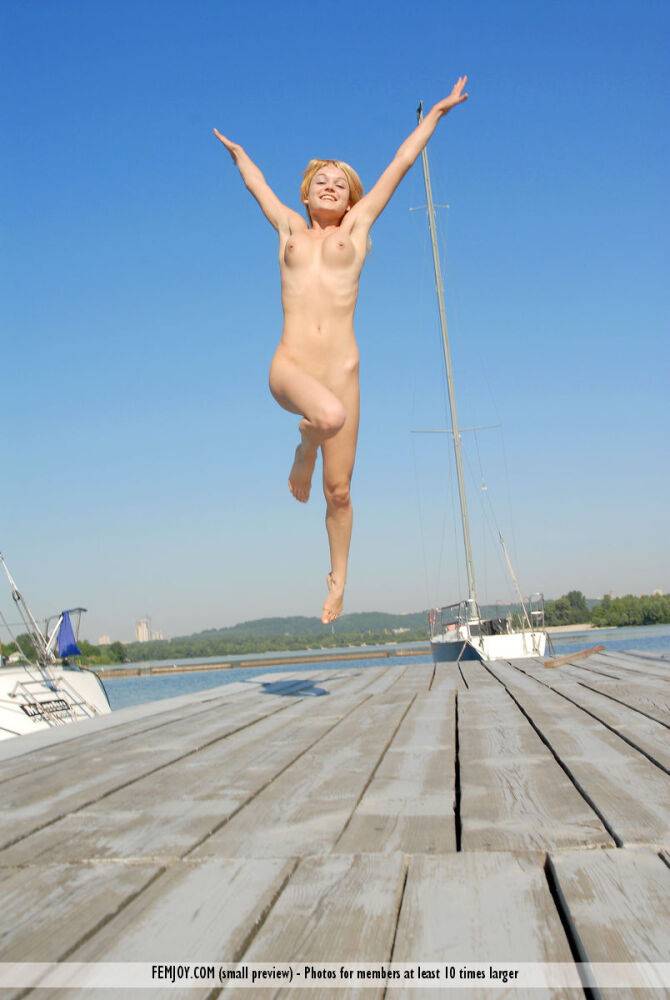 Blonde girl Addie models completely naked on a wharf in a sexy manner - #15