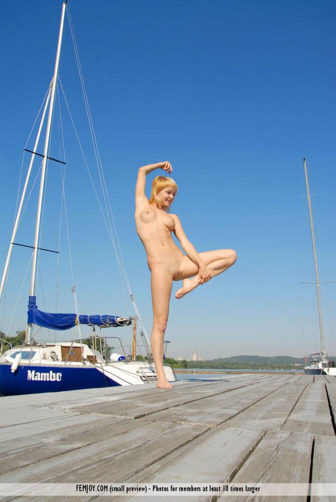 Blonde girl Addie models completely naked on a wharf in a sexy manner - #11