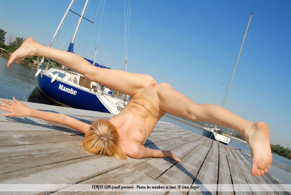 Blonde girl Addie models completely naked on a wharf in a sexy manner - #12