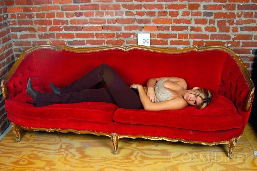 Dirty blonde female relaxes on a red sofa while removing her leggings - #10