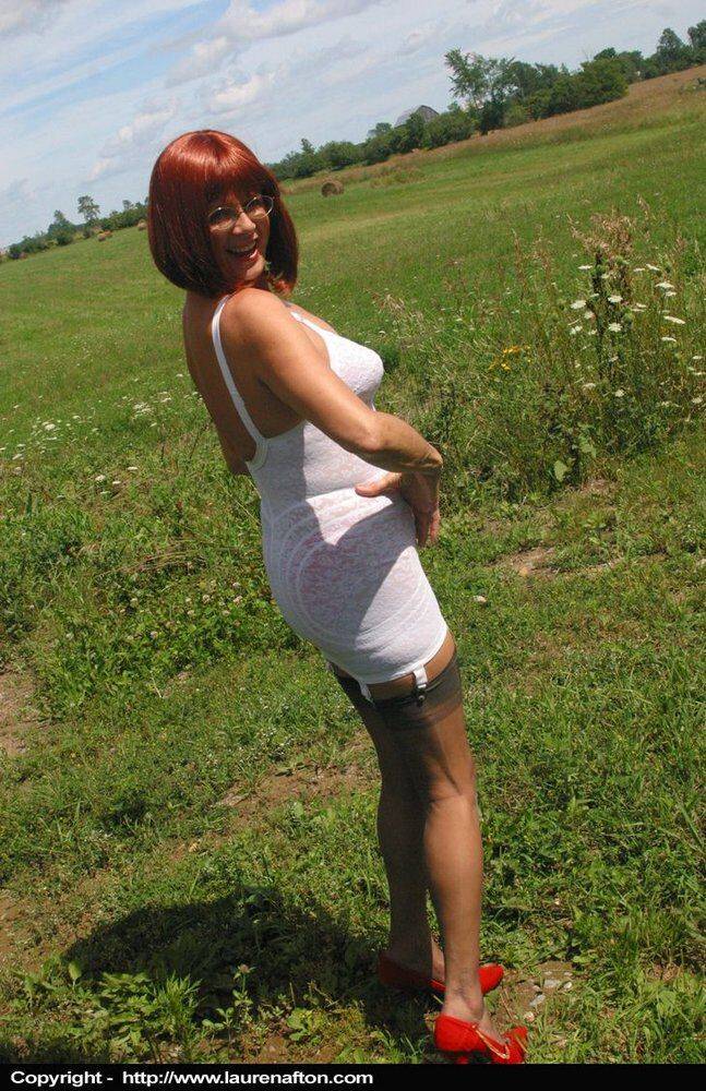 Older redhead Lauren models a retro girdle and nylons in a field - #12