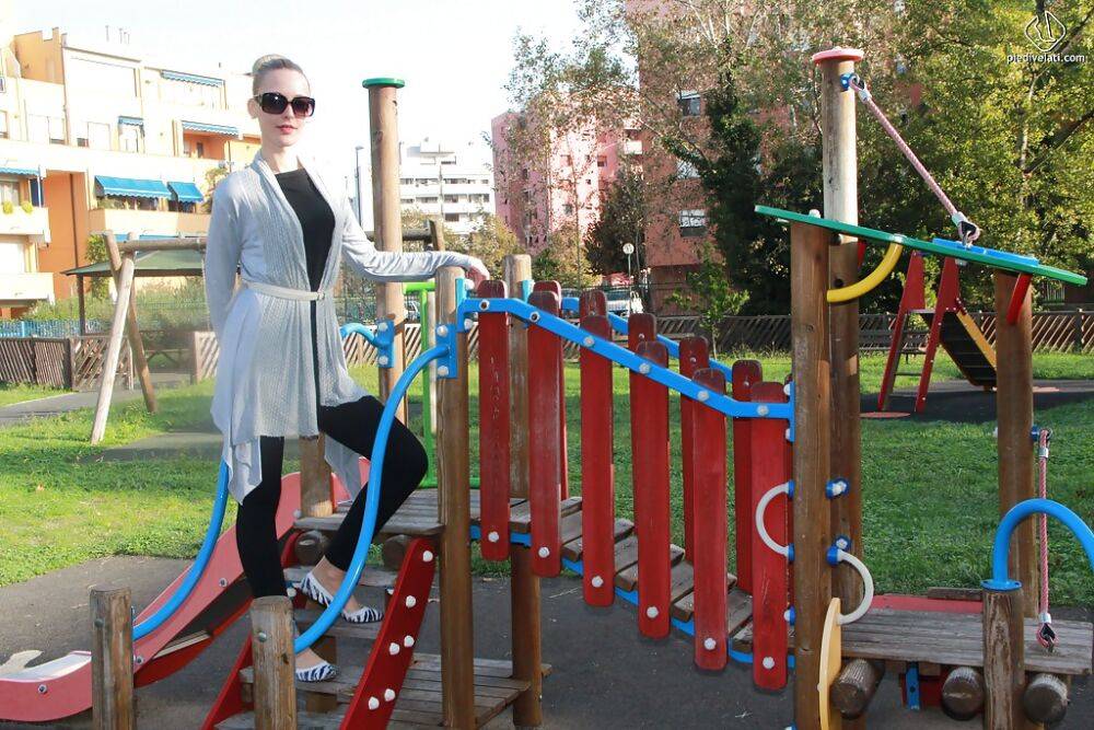 Lovely Christelle is showing her fine feet on a children playground - #15