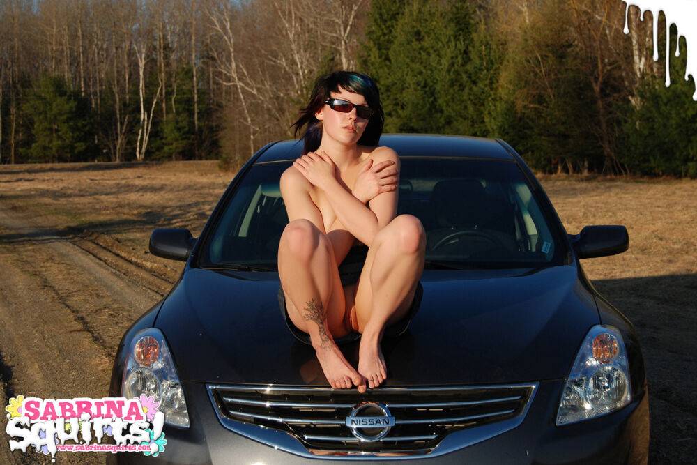 Young brunette Sabrina Squirts shows her tits and twat on top of a car - #6