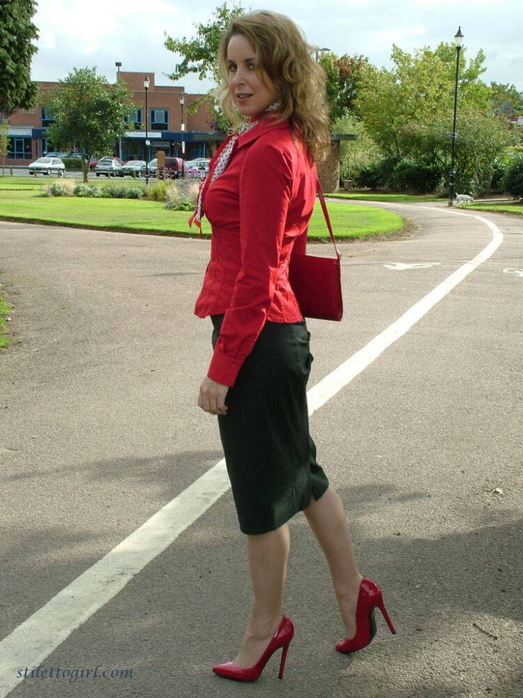 Mature woman crosses her hose covered legs in a long skirt and red pumps - #1