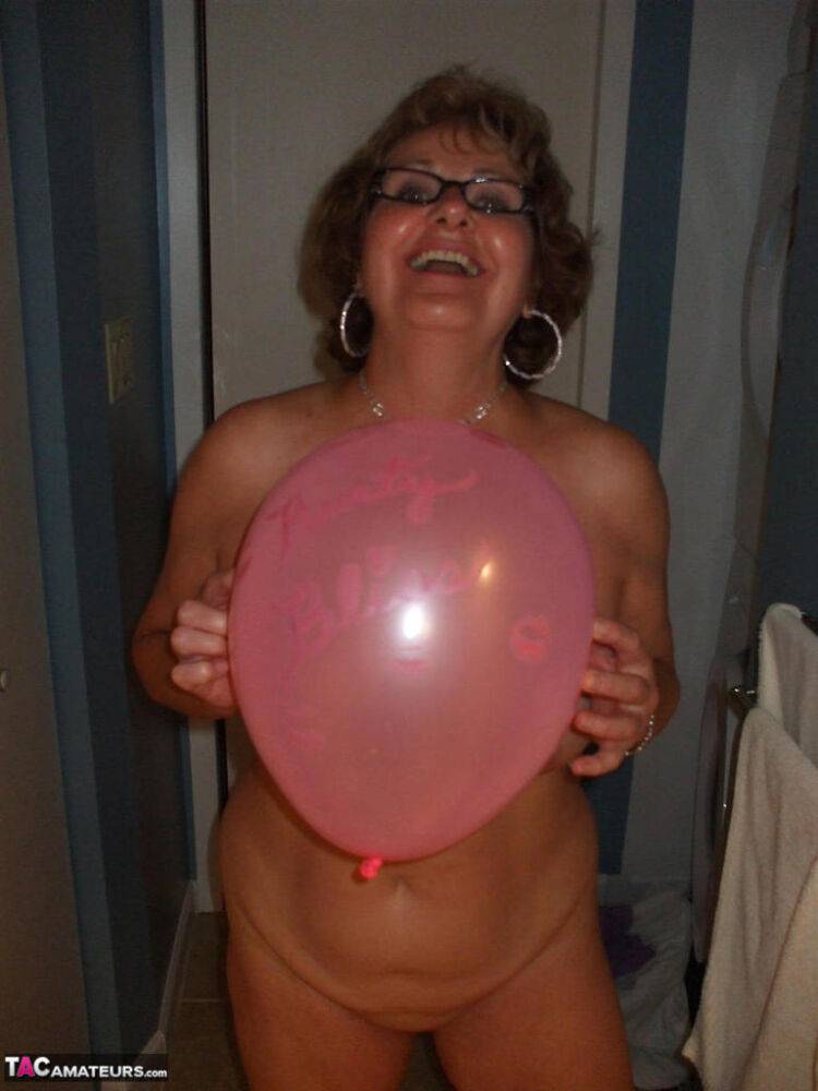 Mature lady models totally naked while playing with balloons - #4