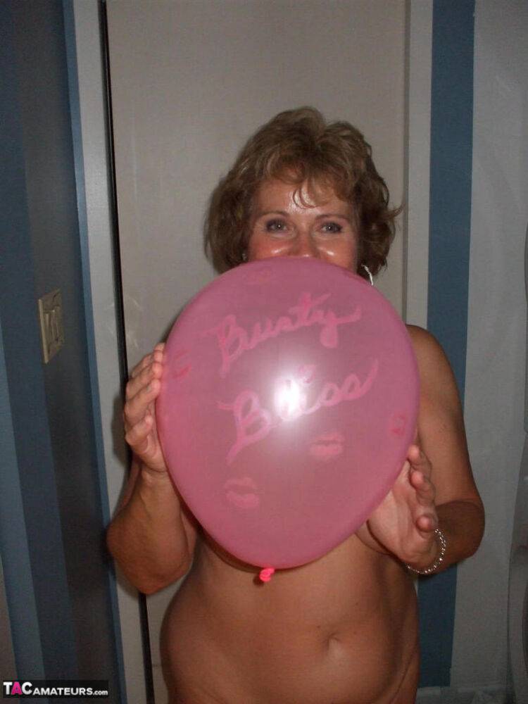 Mature lady models totally naked while playing with balloons - #10