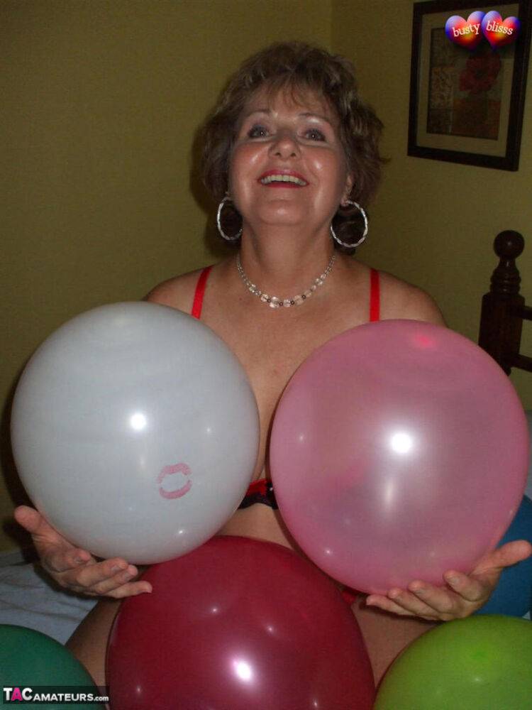 Mature woman Busty Bliss goes topless on her bed while playing with balloons - #5
