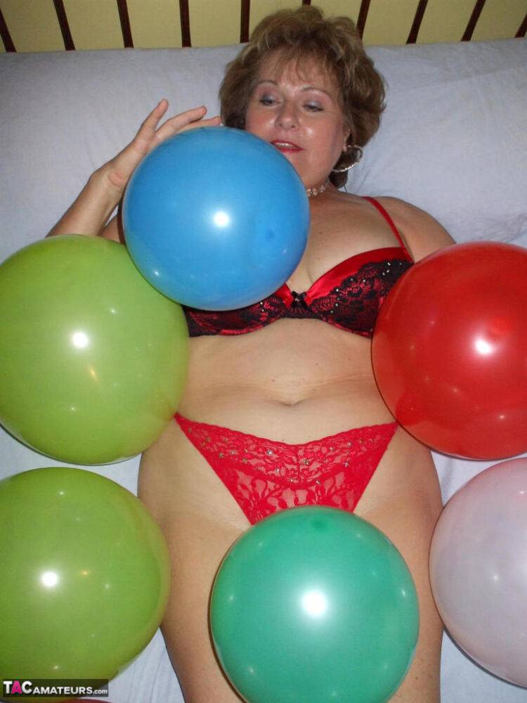 Older lady Busty Bliss plays with balloons before uncupping her natural tits - #9