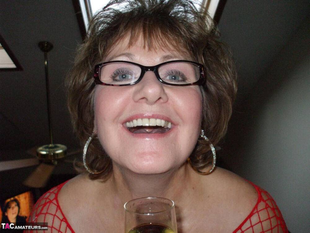 Mature lady in a fishnet dress and glasses drinks wine before stroking cock - #9