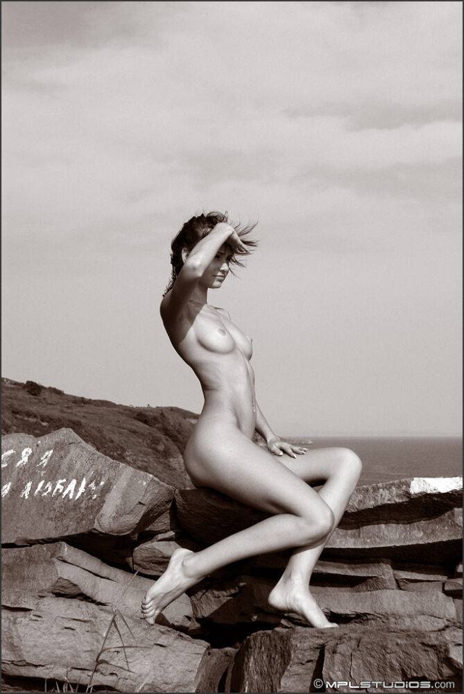 Leggy solo girl models naked on top of rocky oceanside outcrop - #11