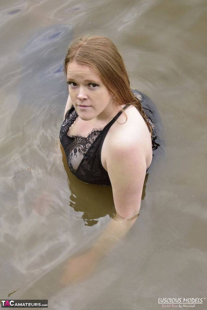 Redheaded amateur Luscious Models wades into a body of water in lingerie - #1