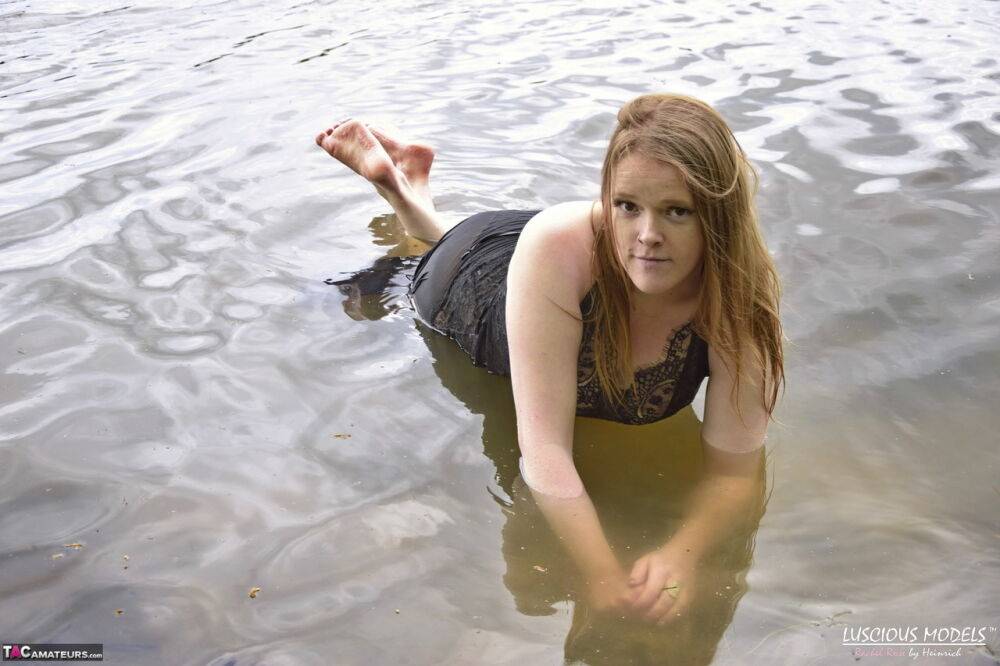 Redheaded amateur Luscious Models wades into a body of water in lingerie - #11