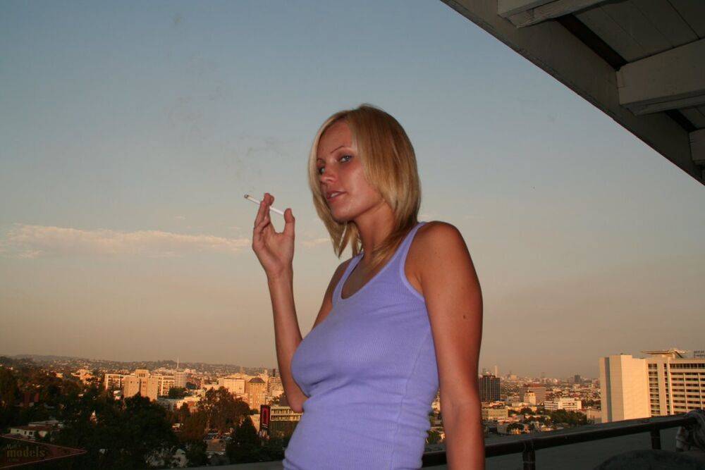 Blonde chick causally displays no panty upskirt while smoking on condo balcony - #7